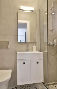 a bathroom with a white sink and a mirror at Centro Apartments by Comfortbnb- Sitia in Sitia