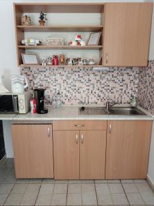 cocina con fregadero y microondas en Hársfa apartman, en Makó