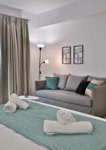 a living room with a couch and two towels at Centro Apartments by Comfortbnb- Sitia in Sitia