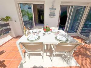 een witte eettafel met twee stoelen en een tafel met stoelenblad bij Apartamento Golf Valle Romano in Estepona