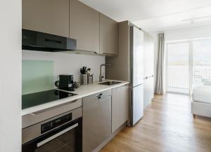 Una cocina blanca con fregadero y estufa. en Fantastic studio with balcony - 323, en Odense