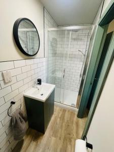 a bathroom with a sink and a shower with a mirror at Brantwood Apartments - Apartment 3 in Manchester