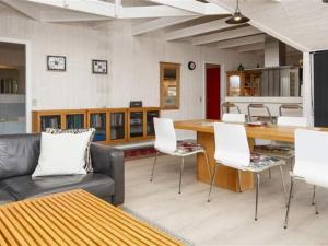 een woonkamer met een bank en een tafel en stoelen bij Holiday Home Herma - all inclusive - 1km from the sea by Interhome in Fanø