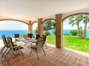 a patio with a table and chairs and the ocean at Villa Atardecer by Interhome in Torrox Costa +41 photos