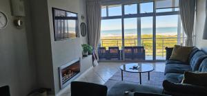 a living room with a fireplace and a view of the ocean at Beachfront 3-bedroom with Robben Island views in Cape Town