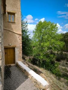 ein Gebäude mit einer Holztür und einem Baum in der Unterkunft Cara Norte , Casa Rural-Castillo de Villamalefa 
