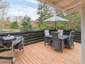 a grill on a deck with a table and chairs at Holiday Home Betti - all inclusive - 700m from the sea by Interhome in Vester Sømarken