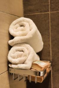 a pile of towels on a towel rack in a bathroom at Astoria Apartments Lovely One Bedroom Apartment With AC & UPS in Lavington in Nairobi