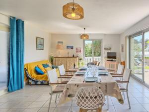 ein Wohnzimmer mit einem langen Tisch und Stühlen in der Unterkunft Holiday Home Port Morvan by Interhome in Planguenoual + 31 Fotos
