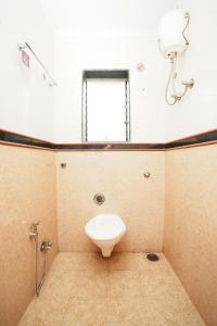 a bathroom with a toilet and a window at Springfield Family Apartment in Mahabaleshwar