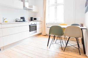 a kitchen with a table and chairs in a room at Spacious and cool 1-bed in Øgadekvarteret - 57 in Aarhus +2 photos