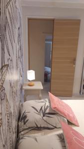 ロクブリュヌ・カップ・マルタンにあるLa Bombonière & Spaのベッドルーム1室(ベッド1台、ランプ付きテーブル付)