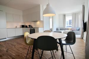 a kitchen and living room with a table and chairs at Stunning 2-bed w balconies and fantastic views in Copenhagen