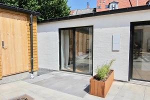 a house with sliding glass doors on the side of it at Private 1-bed townhouse w terraces in Aarhus