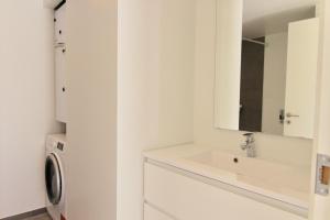a bathroom with a sink and a washing machine at Private 1-bed townhouse w terraces in Aarhus