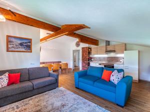 ein Wohnzimmer mit 2 blauen Sofas und einer Küche in der Unterkunft Apartment Mawa by Interhome in Haus im Ennstal