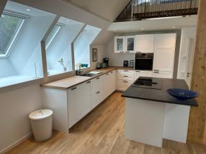a kitchen with white cabinets and a counter top at Moderne Wohnung :: traumhafte Natur in Moholm
