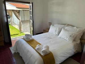 a bedroom with a white bed with towels on it at Mindelo's Residence in Mindelo