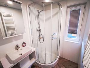 a white bathroom with a shower and a sink at Holiday Home Tiny Haus Christas Angler-Oase by Interhome in Riedenburg