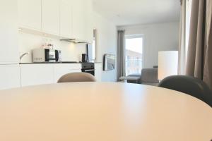 a table in a room with chairs and a kitchen at Fantastic 1-bed w balcony in Ørestaden in Copenhagen