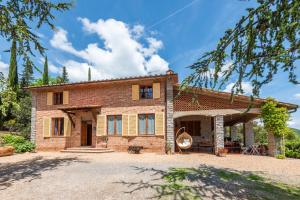 a large brick house with a tree at Vertine Countryside in Gaiole in Chianti