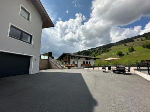 a house with a garage and a grassy hill at Willi's Holidays Home in Saalbach-Hinterglemm