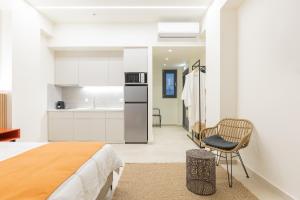 a bedroom with a bed and a kitchen at Nostos Suites in Kourouta