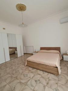 a bedroom with a bed and a tiled floor at Casa vacanze 'Dalla Nonna' in Mesagne