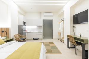 a bedroom with a bed and a desk and a kitchen at Nostos Suites in Kourouta