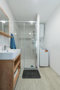 a bathroom with a shower and a sink and a refrigerator at Luxury mobile home HIMALAJA, Oaza mira, Drage in Drage