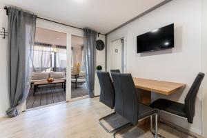 a dining room with a table and chairs and a couch at Luxury mobile home HIMALAJA, Oaza mira, Drage in Drage