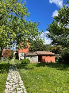 un camino de piedra junto a un edificio en un campo en B&B Terre Di Bea, en Pederobba