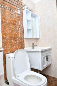 a bathroom with a white toilet and a sink at The Wills 3 Bedroom Apartment in Nairobi in Nairobi