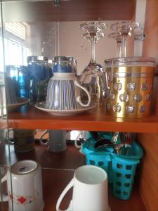 a shelf with a bunch of kitchen items on it at Pearl Furnished Home in Buloba