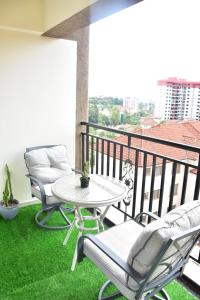 a patio with a table and chairs on a balcony at The Wills 3 Bedroom Apartment in Nairobi in Nairobi