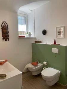 a bathroom with a white toilet and a sink at Villa Krafft Bed&Breakfast in Waake