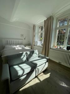 a bedroom with a bed and two windows at Villa Krafft Bed&Breakfast in Waake