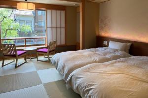 Postel nebo postele na pokoji v ubytování Akaishiya 城崎温泉旅館 赤石屋