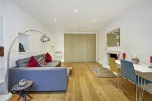 - un salon avec un canapé bleu et une table dans l'établissement Boutique Studio Flat in Notting Hill Gate, à Londres