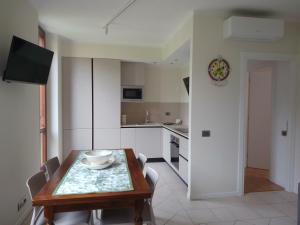 a kitchen with a wooden table and a dining room at Casa Gabry Bouganville in Toscolano Maderno