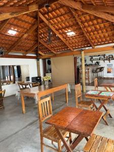 サン・ジョアン・バチスタ・ド・グローリアにあるPousada Sempre Vivaの木製のテーブルと椅子が備わる広い客室です。