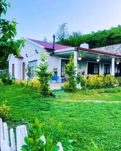 ein weißes Haus mit einem Zaun im Hof in der Unterkunft Trabzon saklı villa in Akcaabat