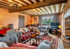 uma sala de estar com um sofá e uma televisão em Corner Farm Cottage em Rumburgh