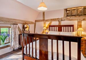 um quarto com uma cama de madeira e uma escada em Corner Farm Cottage em Rumburgh