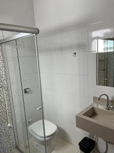 een badkamer met een douche, een toilet en een wastafel bij Pousada Sempre Viva in São João Batista do Glória