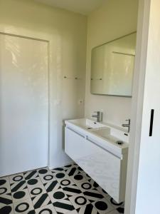een badkamer met een wastafel en een spiegel bij Maison vacances Bassin d'Arcachon in Gujan-Mestras