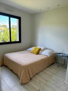 1 dormitorio con 1 cama, ventana y mesa en Maison vacances Bassin d'Arcachon en Gujan-Mestras