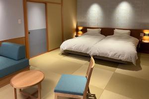 Postel nebo postele na pokoji v ubytování Akaishiya 城崎温泉旅館 赤石屋