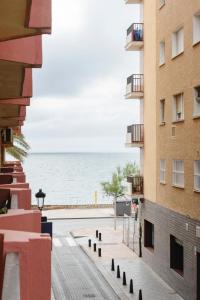 Blick auf den Strand zwischen den Gebäuden in der Unterkunft Apartamento primera linea de playa Fuengirola in Fuengirola