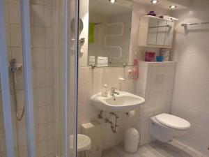 a bathroom with a sink and a toilet and a shower at Ferienhaus "Hauß" Objekt ID 12063-3 in Waren +8 photos